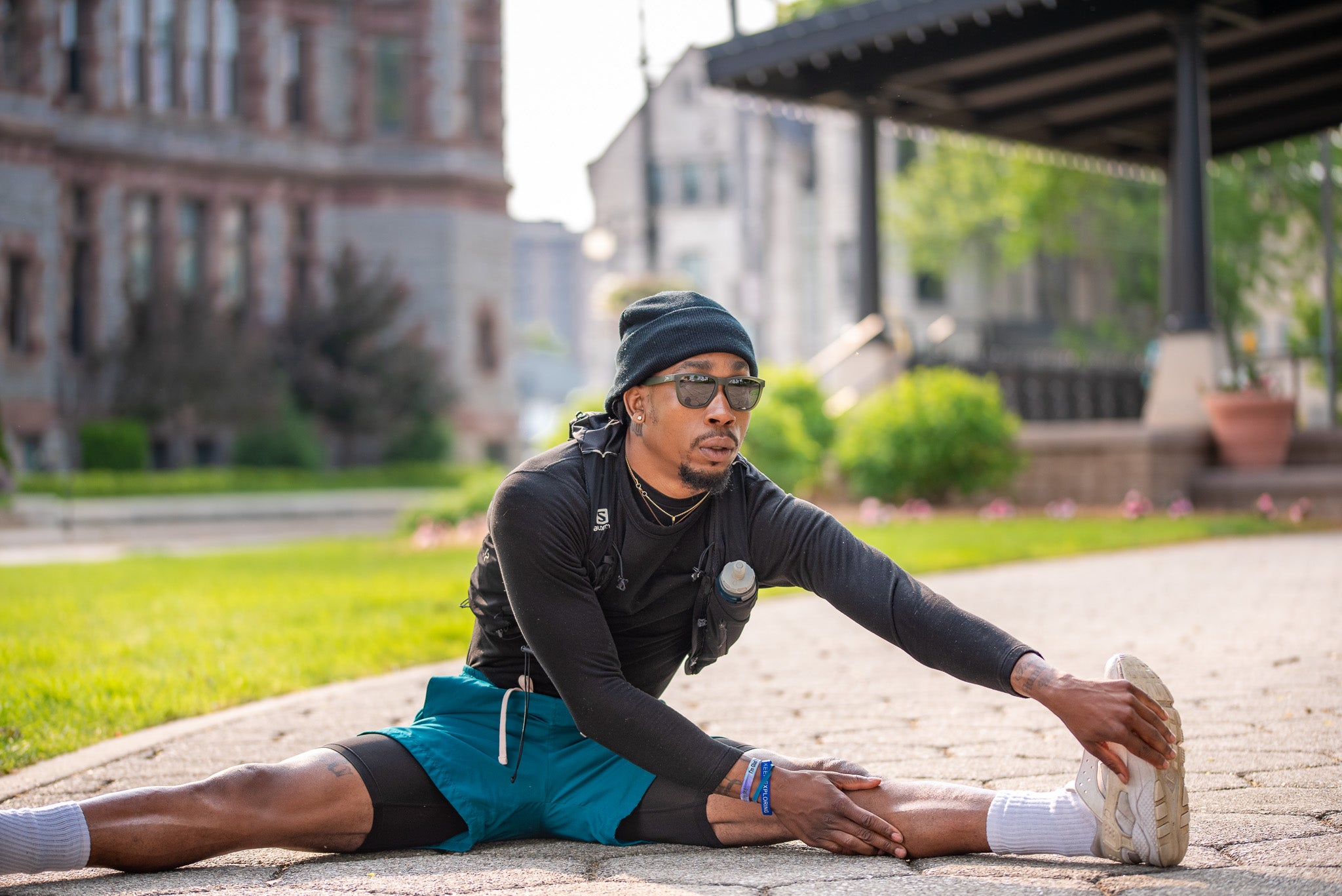 Man wearing mirrored goggles and gray beanie, holding skis in a snowy setting.