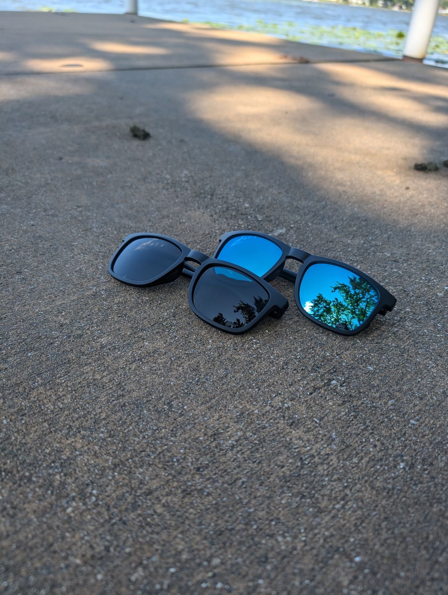 Man wearing mirrored goggles and gray beanie, holding skis in a snowy setting.