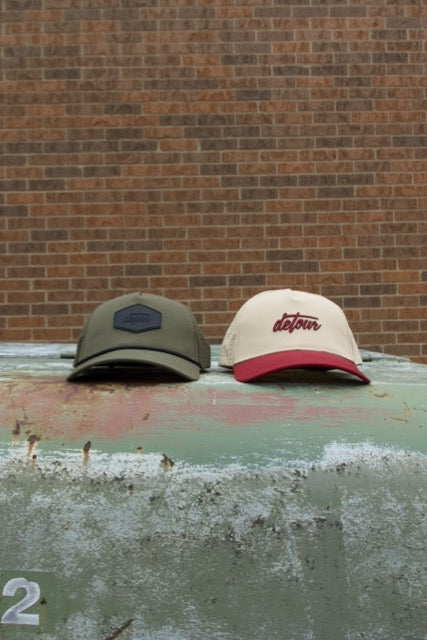Man wearing mirrored goggles and gray beanie, holding skis in a snowy setting.