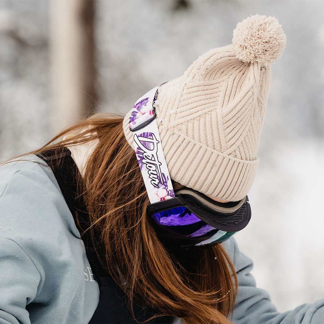 Snowboarder in dark gear with goggles on a snowy mountain.